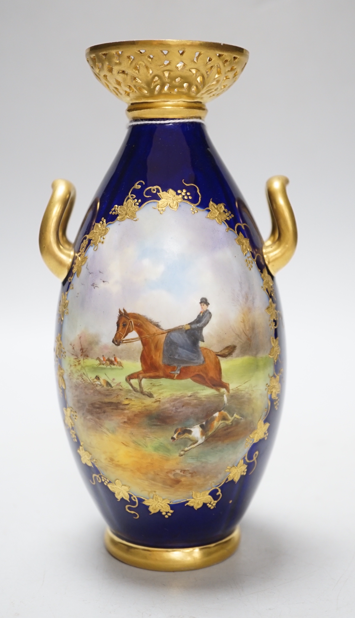 A Grainger & Co. Worcester two handled vase painted with a fox hunting scene in a raised gilt panel on a cobalt blue ground, having a reticulated gilt neck, date mark 1898, 19cm high